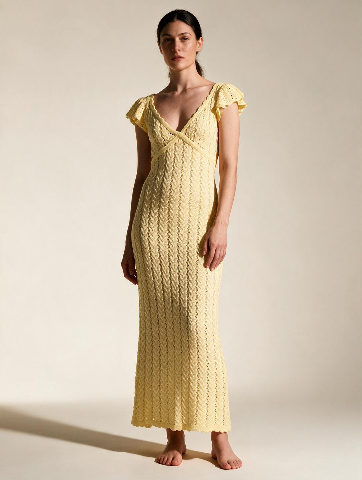 Elettra Ferri V-neck openwork maxi dress worn by a model, featuring a flowing silhouette and intricate openwork details.