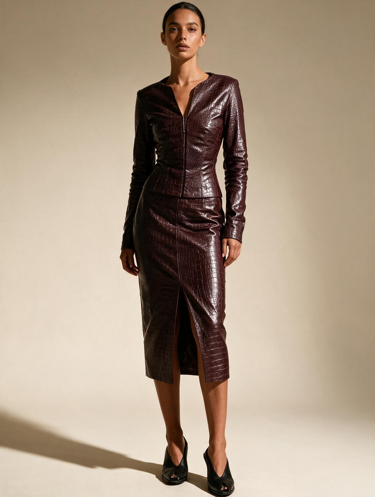 Model wearing Elettra Ferri burgundy leather jacket and midi skirt set, showcasing stylish, coordinated leather fashion ensemble.