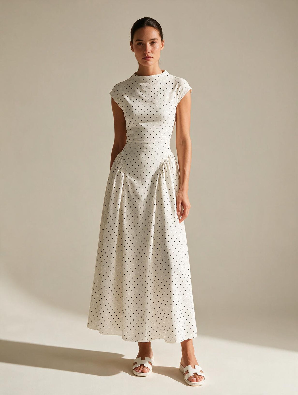 Elettra Ferri polka dot slim maxi dress with a fitted silhouette and flowing fabric, featuring a classic black and white dot pattern.